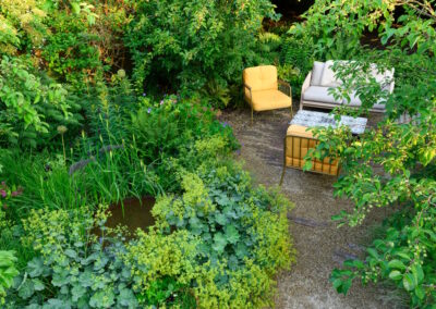 Garden with modern furniture, flexible seating layout and wildlife planting in Surrey.